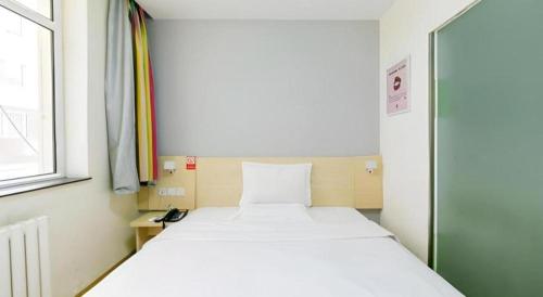 a small room with a bed and a window at 7 Days Inn Hohhot Hailiang Xinhua Square Metro Station in Hohhot