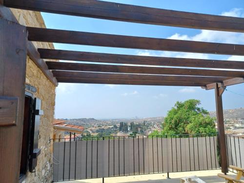 a patio with a wooden pergola and a fence at Kleanthis House in Tochni