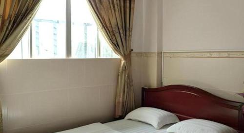 a bed in a room with a window and a bed sidx sidx sidx at Quang Sang Hotel Can Tho in Can Tho