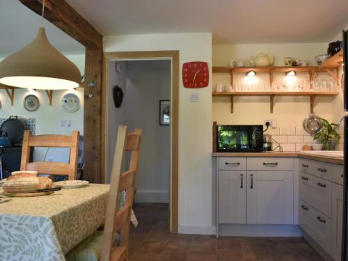 a kitchen with a table and a dining room at Beech Tree Cottage At Blackaton Manor Farm in Widecombe in the Moor