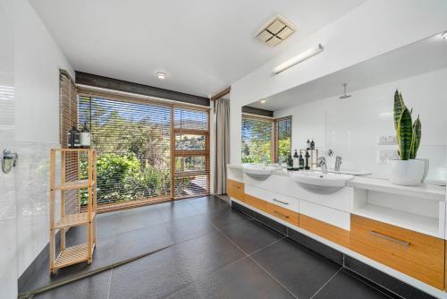 un bagno con due lavandini e una grande finestra di Huon Valley House a Ranelagh