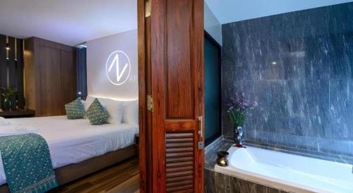 a bathroom with a tub and a bed and a bathtub at B2 Krabi Premier Hotel in Ao Nang Beach