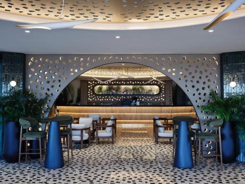 a restaurant with an archway and tables and chairs at Rodos Princess Beach Hotel in Kiotari