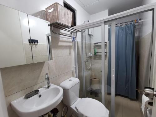 a bathroom with a toilet and a sink and a shower at Coastal Stay at Oceancrest in Cebu City