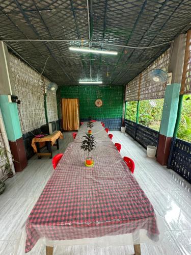 a long table in a room with red chairs at Purple Orchid in Kāziranga