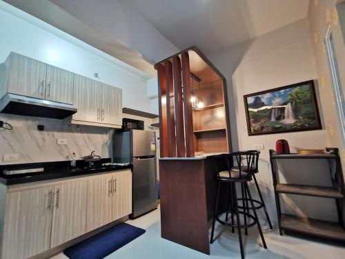 a kitchen with a counter and a bar in it at Coastal Stay at Oceancrest in Cebu City