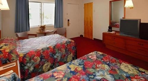 a hotel room with two beds and a flat screen tv at Baymont by Wyndham Lake George in Lake George