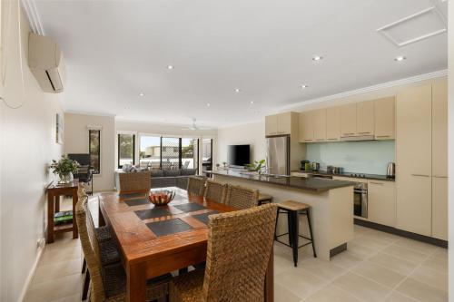 a kitchen and dining room with a wooden table and chairs at Brooklya by the Beach in Cowes