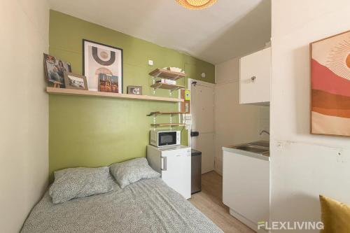 une petite chambre avec un lit et une cuisine dans l'établissement Flexliving - Studio - Hopital, à Paris