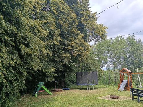 a park with playground equipment and a tree at Domek pod lipami in Dwikozy