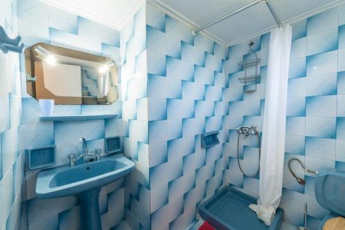 a blue and white bathroom with a sink and a shower at Villa-Toula in Roda