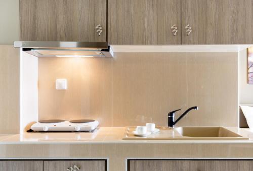 a kitchen counter with a sink and a stove at Troia Resort Luxury Studios in Asprovalta