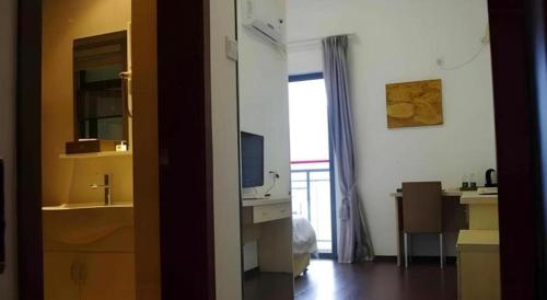 a room with a sink and a desk with a television at The Century Seaview Hotel in Shenzhen