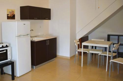 a kitchen with a white refrigerator and a table with chairs at Kripis Studio Paliouri in Paliouri