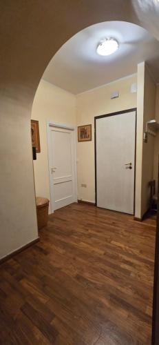 an empty room with a white door and wooden floors at La Terrazza 2P Rooms in Abbadia San Salvatore