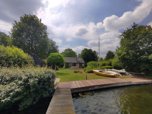 a boat sitting on a dock next to a house at Waterfront house with big garden in Arnemuiden