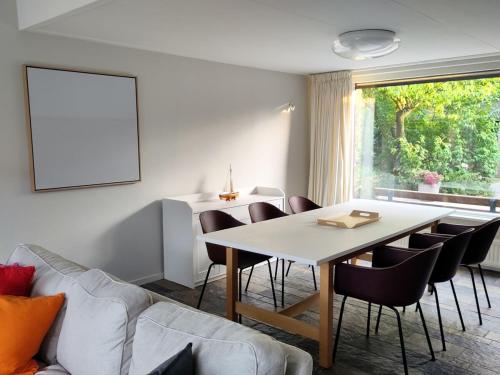 a living room with a table and chairs at Waterfront house with big garden in Arnemuiden