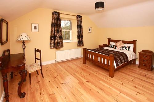 a bedroom with a bed and a desk and a window at Brownes Farm House- relisted for 2022 in Ballymacart Bridge