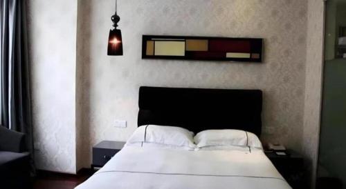 a bedroom with a white bed and a window at Yiwu Baiheng Hotel in Yiwu