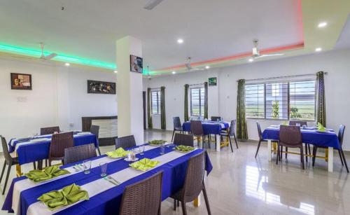a meeting room with blue tables and chairs in it at La Vue Resort in Hatikhuli