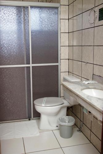 a bathroom with a toilet and a sink and a shower at Royal Inn Hotel in Cornélio Procópio