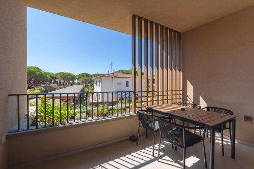 a balcony with a table and chairs and a large window at Campoblù in Marina di Campo
