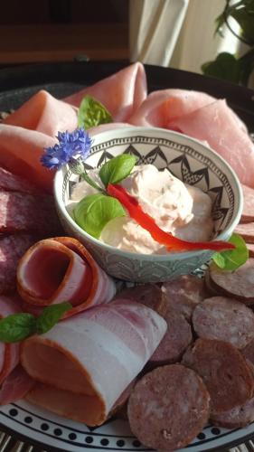 a plate of food with meat and a bowl of dip at Apartmán v Podhradí Boskovice in Blansko