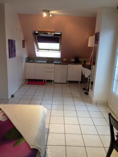 an empty kitchen with a table and a window at L'Eden Orly Aéroport in Thiais