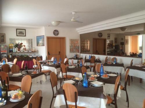 a dining room with tables and chairs in a restaurant at Hotel Tre Grazie in Rimini