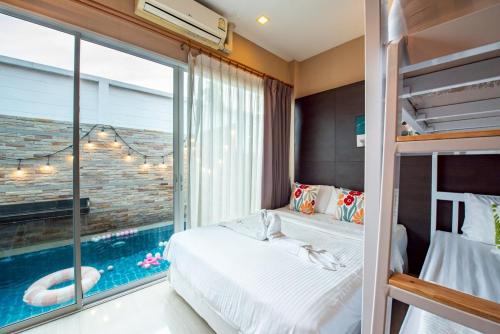 two beds in a bedroom with a swimming pool at Phirom3 pool villa pattaya in Jomtien Beach