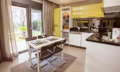 a kitchen with yellow cabinets and a table with chairs at BMK APART Otel in Antalya