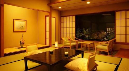 a living room with a table and chairs at Shiratamano Yu Kahou in Shibata