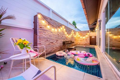a swimming pool with a table and chairs on a patio at Phirom3 pool villa pattaya in Jomtien Beach