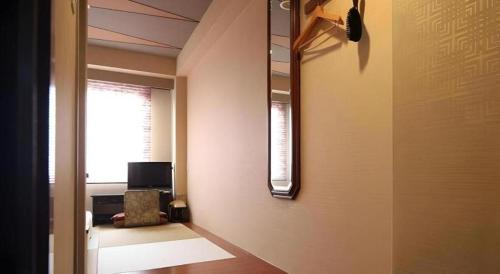 a hallway with a room with a window and a chair at Suigetsurou Hotel in Takaoka