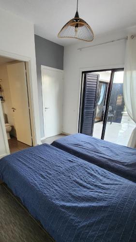 a bedroom with two beds with a blue blanket at Larnaca Breeze in Pyla