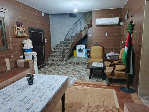 a living room with a staircase and a table and chairs at Top "OverView" Resort اطلالة القمة in Al ‘Āmirīyah
