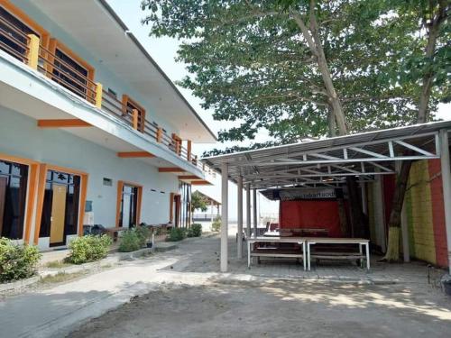 a picnic table under awning outside of a building at RST NWR Pulau Tidung in Pulau Tidung-besar