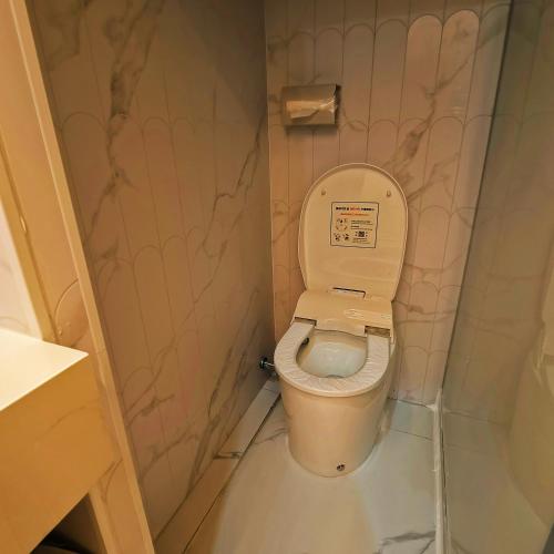 a small bathroom with a toilet in a stall at 上海璞逸酒店-豫园 新天地 老西门地铁站店 in Shanghai