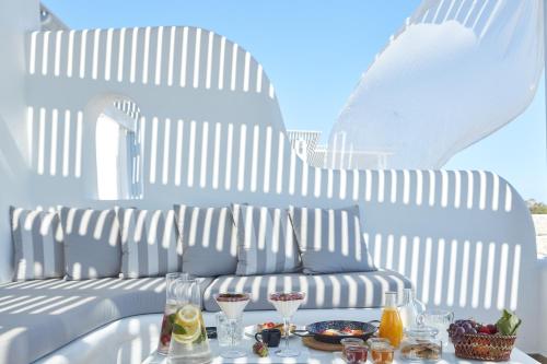a table with drinks on it with a couch in the background at Orabel Suites Santorini (Adults Only) in Perivolos