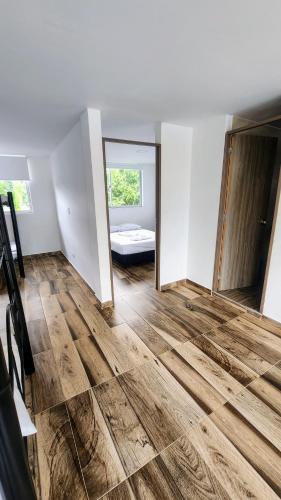 an empty room with a wooden floor and a mirror at Lila Alojamiento Campestre in Melgar