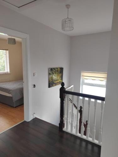 a white room with a staircase and a bed at Teach Abhaile Donegal 