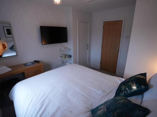 a bedroom with a bed and a tv on the wall at Romsey Brewery House - circa 1893 in Romsey