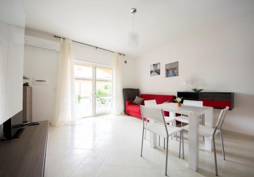 a living room with a white table and a red couch at Pizzo Beach Club in Pizzo