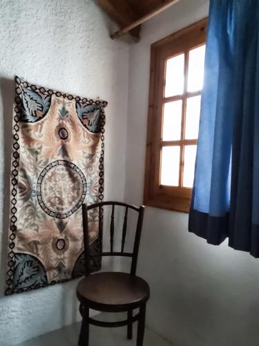 a chair in a room with a pillow and a window at Moorea Country Houses in Petalidhion