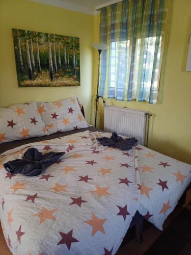 a bed with stars on it in a bedroom at Czanadomb apartman in Cserkút
