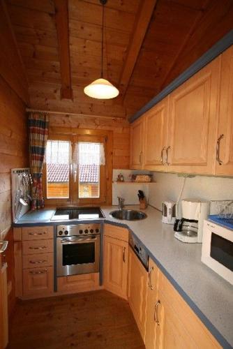 a kitchen with wooden cabinets and a stove top oven at Naturerlebnisdorf Stamsried 3 in Stamsried