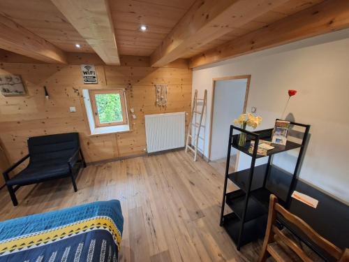 Cette chambre comprend un lit et une chaise. dans l'établissement Appartement du bois des Fugiers, à Ugine