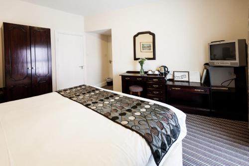 Una cama o camas en una habitación de Munster Arms Hotel