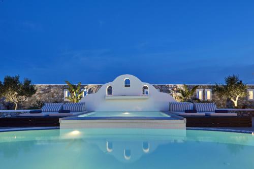 a swimming pool at night with a villa in the background at Orabel Suites Santorini (Adults Only) in Perivolos
