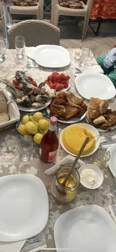 a table with plates of food on it at Camping Casa Lipoveanului in Chilia Veche